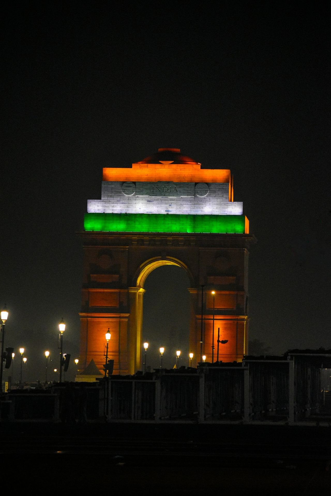 a very tall clock tower with a green and white flag on it's side
